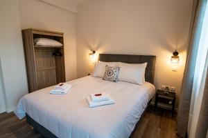 a bedroom with a bed with two towels on it at Andromeda apartments in Spata