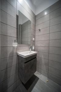 een badkamer met een wastafel en een spiegel bij Andromeda apartments in Spáta
