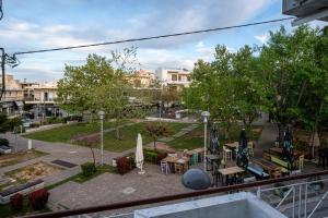 uitzicht op een park met tafels en parasols bij Andromeda apartments in Spáta