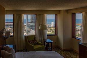 a hotel room with a bed and a chair and windows at Cleveland Marriott Downtown at Key Tower in Cleveland