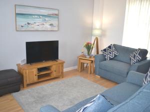 ein Wohnzimmer mit Couch und Flachbildfernseher in der Unterkunft Tammie Norrie Cottage in Banff