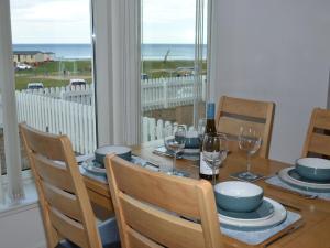 a dining room table with a view of the ocean at Tammie Norrie Cottage in Banff