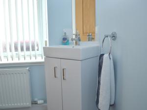 ein Badezimmer mit einem weißen Waschbecken und einem Spiegel in der Unterkunft Tammie Norrie Cottage in Banff + 15 Fotos