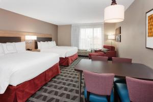 泰特斯維爾的住宿－TownePlace Suites by Marriott Titusville Kennedy Space Center，酒店客房带两张床和一张桌子以及椅子。