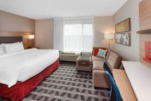 una camera d'albergo con letto e divano di TownePlace Suites by Marriott Titusville Kennedy Space Center a Titusville