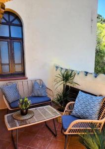 2 rieten stoelen en een tafel op een patio bij Residence Blue living in Tortolì