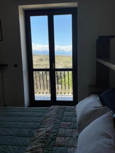 una camera con letto e finestra con vista di Spicchio di Langa - casa indipendente tra le vigne e le Alpi a Belvedere Langhe