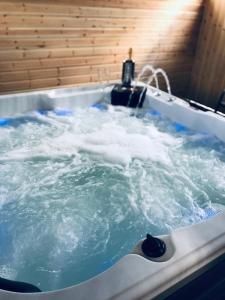 una bañera de hidromasaje llena de agua en una habitación en Ardmore Log Cabins en Drumahoe