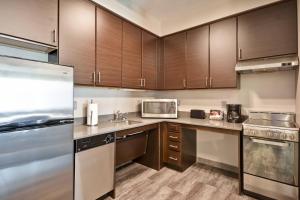 a kitchen with stainless steel appliances and wooden cabinets at TownePlace Suites by Marriott Cranbury South Brunswick in Cranbury