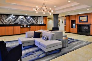 a living room with white furniture and a fireplace at Fairfield Inn & Suites Raleigh-Durham Airport/Brier Creek in Durham