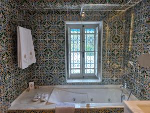 a bathroom with a bath tub and a window at La Menara Hotel & SPA in Sidi Bou Saïd