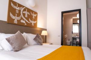 a bedroom with a white bed and a bathroom at Palazzo Indelli in Monopoli