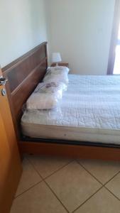 Ce lit se trouve dans un dortoir doté d'un cadre en bois. dans l'établissement Villa Flipper, à Bellaria-Igea Marina