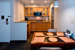 a kitchen with a wooden table and a microwave at Residence Inn Syracuse Carrier Circle in East Syracuse