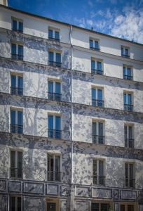 eine Fassade eines Gebäudes mit Fenstern in der Unterkunft Apostrophe Hôtel in Paris