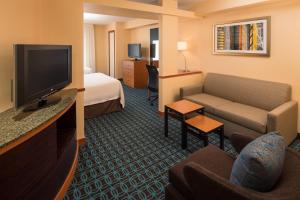une chambre d'hôtel avec un canapé et une télévision dans l'établissement Fairfield Inn & Suites by Marriott Portland North, à Portland