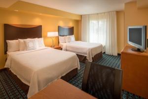 a hotel room with two beds and a flat screen tv at Fairfield Inn & Suites by Marriott Portland North in Portland