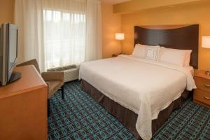 a hotel room with a bed and a flat screen tv at Fairfield Inn & Suites by Marriott Portland North in Portland