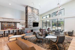 a lobby with a fireplace and tables and chairs at Residence Inn Riverside Moreno Valley in Moreno Valley