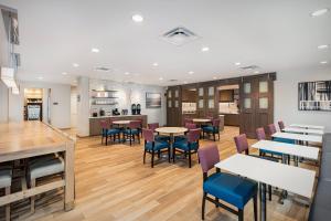 a dining room with tables and chairs and a kitchen at Residence Inn Riverside Moreno Valley in Moreno Valley