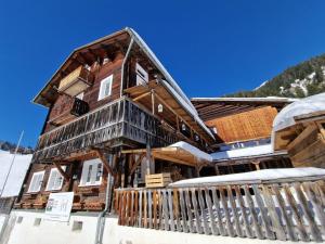 una casa de madera en invierno con nieve en Sonja's Michelshof, en Sankt Antönien