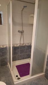 a bathroom with a shower with a purple rug at Casa Millar. in Huergas y El Millar +17 photos