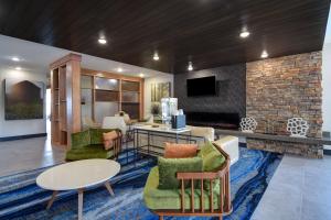 Fairfield by Marriott Inn & Suites Grand Rapids Wyoming في وايومنغ: غرفة معيشة مليئة بالأثاث ومدفأة