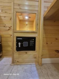 a microwave in a wall in a room with wooden walls at Loft Altos Suite in Puerto Natales