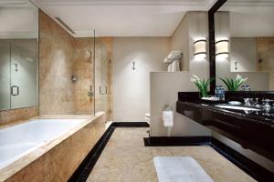 uma casa de banho com uma banheira, um lavatório e um chuveiro em JW Marriott Hotel Jakarta em Jakarta