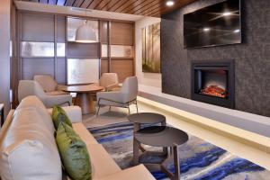 a living room with a couch and a fireplace at Fairfield Inn and Suites by Marriott Minneapolis Shakopee in Shakopee