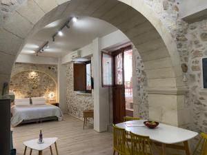 a bedroom with a bed and a table with chairs at Barbara Studios in Rethymno