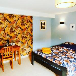 1 dormitorio con cama, escritorio y mesa en Chambres d'hôtes Microbrasserie & Auberge Ortan, en La Canourgue