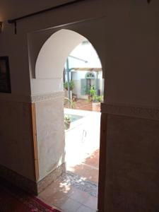 Riad le Jardin de Mina في مراكش: ممر في منزل مع مسبح في الخلفية