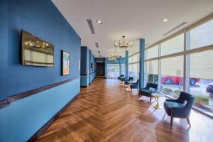 a long hallway with chairs and a blue wall at Four Points by Sheraton Raleigh Durham Airport in Morrisville