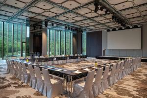 Renaissance Taipei Shihlin Hotel في تايبيه: قاعة المؤتمرات مع طاولة وكراسي طويلة