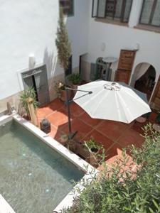 una sombrilla blanca sentada junto a una piscina en Riad le Jardin de Mina, en Marrakech