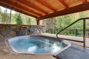 a hot tub on a patio with a wooden roof at Jack Pine 8015 in Keystone