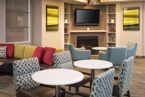 a lobby with a couch and tables and a fireplace at Residence Inn Minneapolis Downtown/City Center in Minneapolis