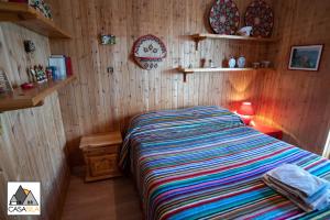 a bedroom with a bed in a room with wooden walls at "CASA SILA", Delizioso appartamento in pieno centro a Camigliatello, 4 posti letto, 2 camere, arredato in vero stile casa di montagna in Camigliatello Silano