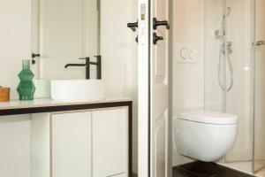 La salle de bains est pourvue de toilettes, d'un lavabo et d'une douche. dans l'établissement The Red Ox - Super Central Canal View Rooms, à Amsterdam