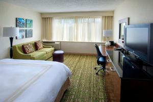 a hotel room with a bed and a flat screen tv at Boston Marriott Peabody in Peabody