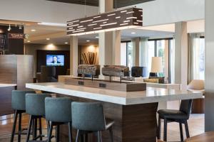a lobby with a bar with chairs and a tv at Courtyard Irvine John Wayne Airport/Orange County in Irvine
