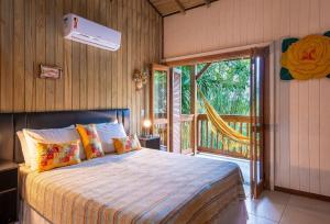 1 dormitorio con cama y ventana grande en Pousada Casa do Ceo, en Praia do Rosa