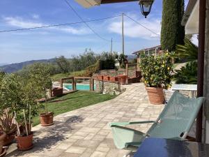 a patio with a blue bench and a swimming pool at Villa l'Uliveta in Montecatini Terme