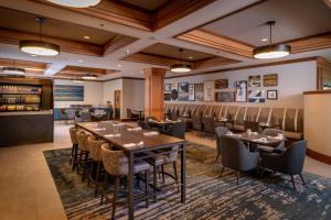 a restaurant with a long table and chairs at Delta Hotels by Marriott Huntington Mall in Barboursville