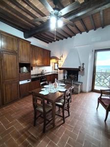 a kitchen with a table with chairs and a stove at APPARTAMENTO CISTERNA 33 in San Gimignano
