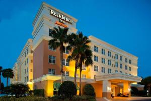 a hotel building with palm trees in front of it at Residence Inn by Marriott Daytona Beach Speedway/Airport in Daytona Beach