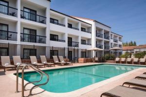 a hotel with a swimming pool and lounge chairs at Courtyard San Jose Cupertino in Cupertino