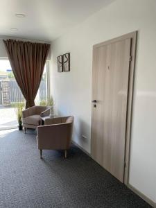 a room with a door and a couch and a chair at Izabelės apartamentai in Palanga