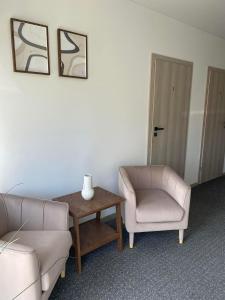 een woonkamer met een bank, een tafel en een stoel bij Izabelės apartamentai in Palanga
